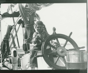Image of Herbert, Leon's boy,  at wheel of Bowdoin 